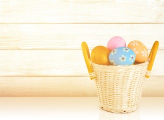 Easter basket filled with colorful eggs on a white background