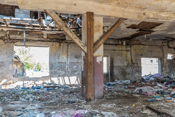 Damaged house, Collapsed roof of the total damaged domestic house indoor from natural disaster or catastrophe with peeled paint and plaster from the walls 