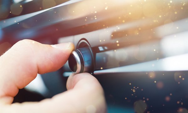 Male Hand Pushing The Power Button To Turn On The Car Stereo System.