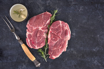 Raw meat steak on dark background. Copy space text concept. Fresh rosemary.