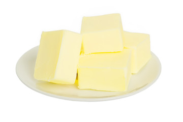 Close-up of fresh butter pieces on a white plate. Plate with butter isolated on white background. Sandwich butter. Natural fat nutrient.