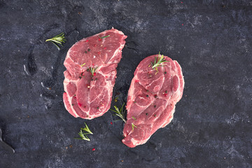 Raw meat steak on dark background. Copy space text concept. Fresh rosemary.