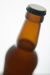 Beer bottle with black cap isolated on white background