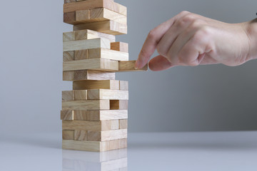 Planning, risk and strategy in business, businessman and engineer gambling placing wooden block on a tower.