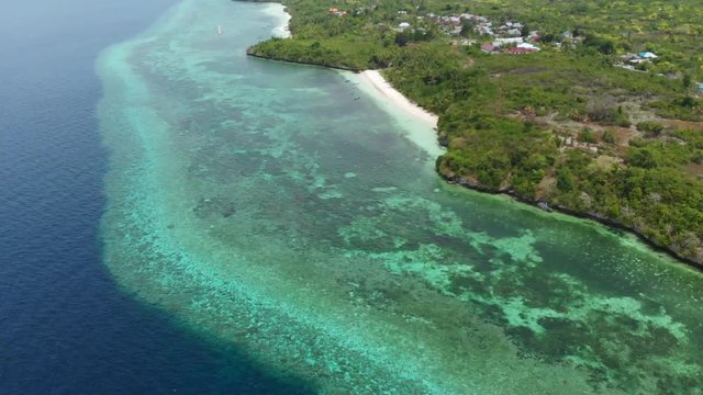 Aerial: Flying over tropical beach turquoise water coral reef , Tomia island Wakatobi National Park Indonesia Maldives Polynesia white sand beach