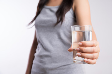 A glass of clean mineral water in woman's hands. Concept of environment protection, healthy drink and healthcare.
