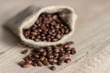 The sack of coffee beans on wooden table