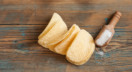 Crispy potato chips in wooden bowl. Salted potato chips.
