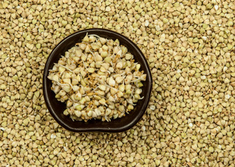 Buckwheat in a wooden bowl on an old wooden table, closeup view