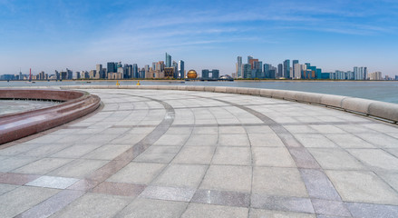 Empty square tiles and skyline of urban buildings..