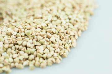Raw green buckwheat pile on white background. Vegan or vegetarian food