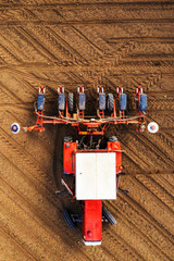 Top view of tractor with seeder from drone pov
