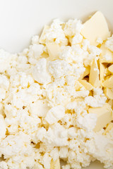 In a mixing bowl are the ingredients butter and cottage cheese for making cookies
