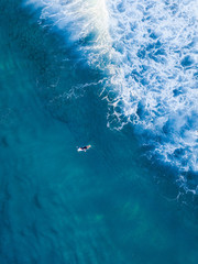 Surfer swimming through the wave foam.