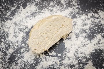 Raw cut dough lies on the table with flour before cooking cottage cheese cookies