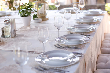 Elegant table set with cutlery, plates and glasses.