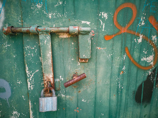 Old, metal garage door with rusty lock. 