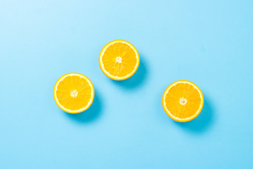 Half cut orange on a blue background. Concept of tropical fruits, vacation and travel, diet and weight loss. Flat lay, top view.