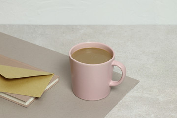 The pink cup of coffee, kraft envelope, notes on the granite texture