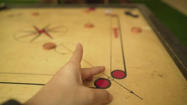 close up at girl  playing carom slow motion, carrom board, indian traditional games
