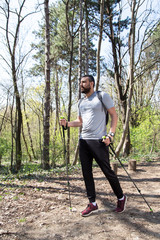 Man walking through a forest wearing a backpack.