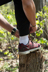 Obraz premium Sportsman tying sneakers in forest
