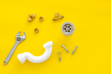 Plumber profession with gear and instruments for repair tubes on yellow background top view