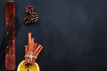 incense sticks with citrus and cinnamon for fresh air on dark background top view mock up