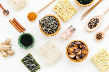 Chinese and Japanese food cooking with ginger, spices and noodles on white background top view geometric pattern
