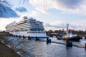 Die Viking Sky aus der Kieler F&ouml;rde kommen bei der Einschleusung in die Holtenauer Schleuse im Abendlicht. unterst&uuml;tzt wird das riesige Schiff dabei von dem Schlepper Stein.