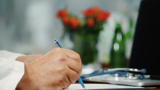 Physician writing medical prespription and shaking hand, close up