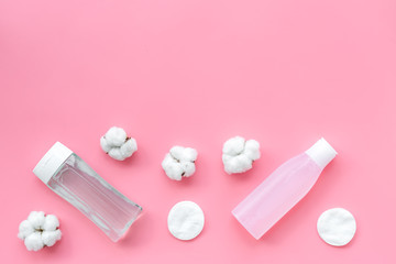 mycelial water, lotion and cotton pads for skin care on pink background flat lay space for text