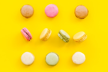 Macarons dessert pattern on yellow background top view