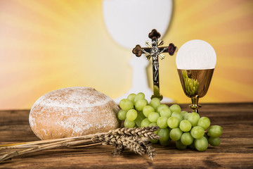 Holy communion a golden chalice with grapes and bread wafers 