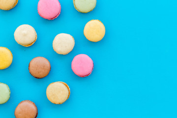 Obraz na płótnie Canvas Macarons dessert pattern on blue background top view copy space