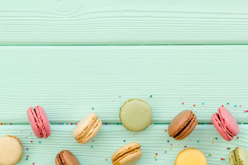 Macarons design on mint green wooden background top view space for text