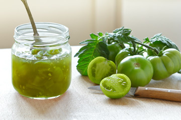 Green tomato jam or chutney in a glass jar with vintage spoon, home canning concept