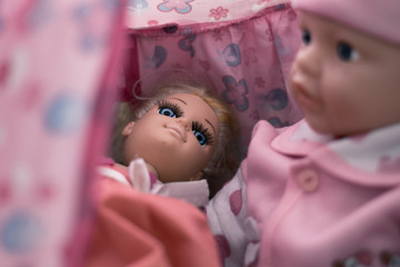 Two dolls in a pink tent. The boy is sitting next to the lying girl. Romantic picnic concept