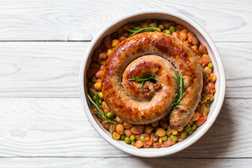Italian sausage - salsiccia fresca, with bean stew and rosemary on a white background