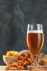 Beer glass with bretzel and dried sausages snacks close up