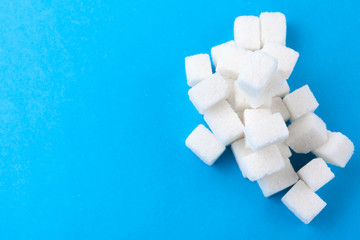 White sugar cubes on a bright blue background