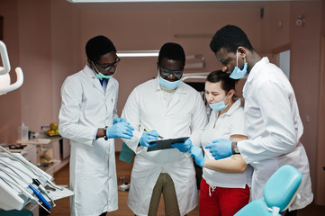 Multiracial dentist doctors team. Three african american male doctors with one caucasian doctor female. Discussion of work moments.
