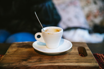 Empty shot glass of Arabica Espresso with coffee stain served on wooden board.