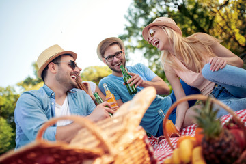 Happy young friends having picnic in the country