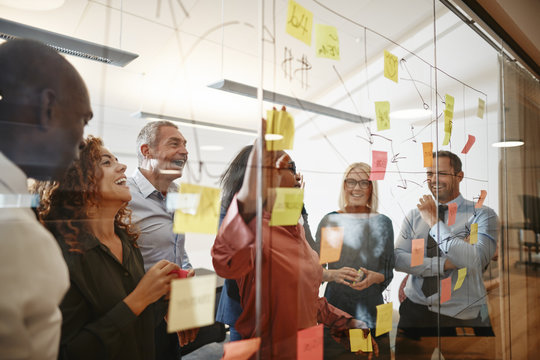 Smiling African businesswoman and her team brainstorming in an o