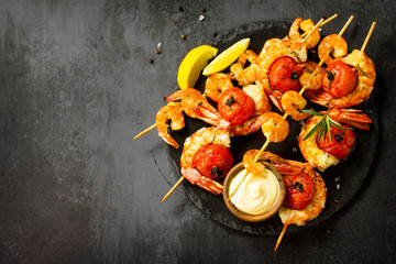 Grilled seafood. Delicious Grilled tiger shrimps with tomatoes, lemon and sauce served on a slate...