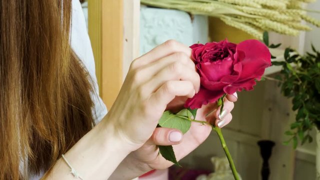 Female florist in flower shop. Woman making a beautiful and stylish bouquet of fresh flowers in floral design studio. 4K