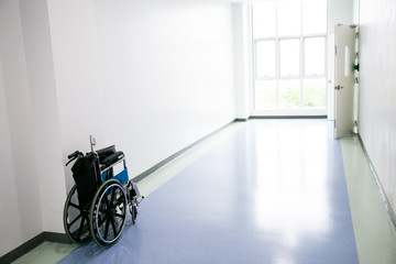 Empty wheelchair parked at corridor of the hospital
