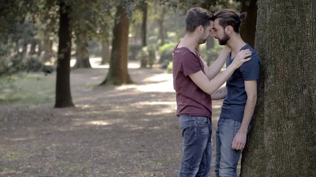shocked woman at the park discovering her boyfriend kissing a man.gay betrayal