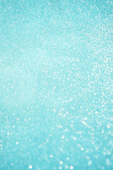 Obraz premium Blurred bokeh light blue background, Christmas and New Year holidays background. Party concept. Festive holiday card bright backdrop. Defocused. Flat lay, top view, copy space.